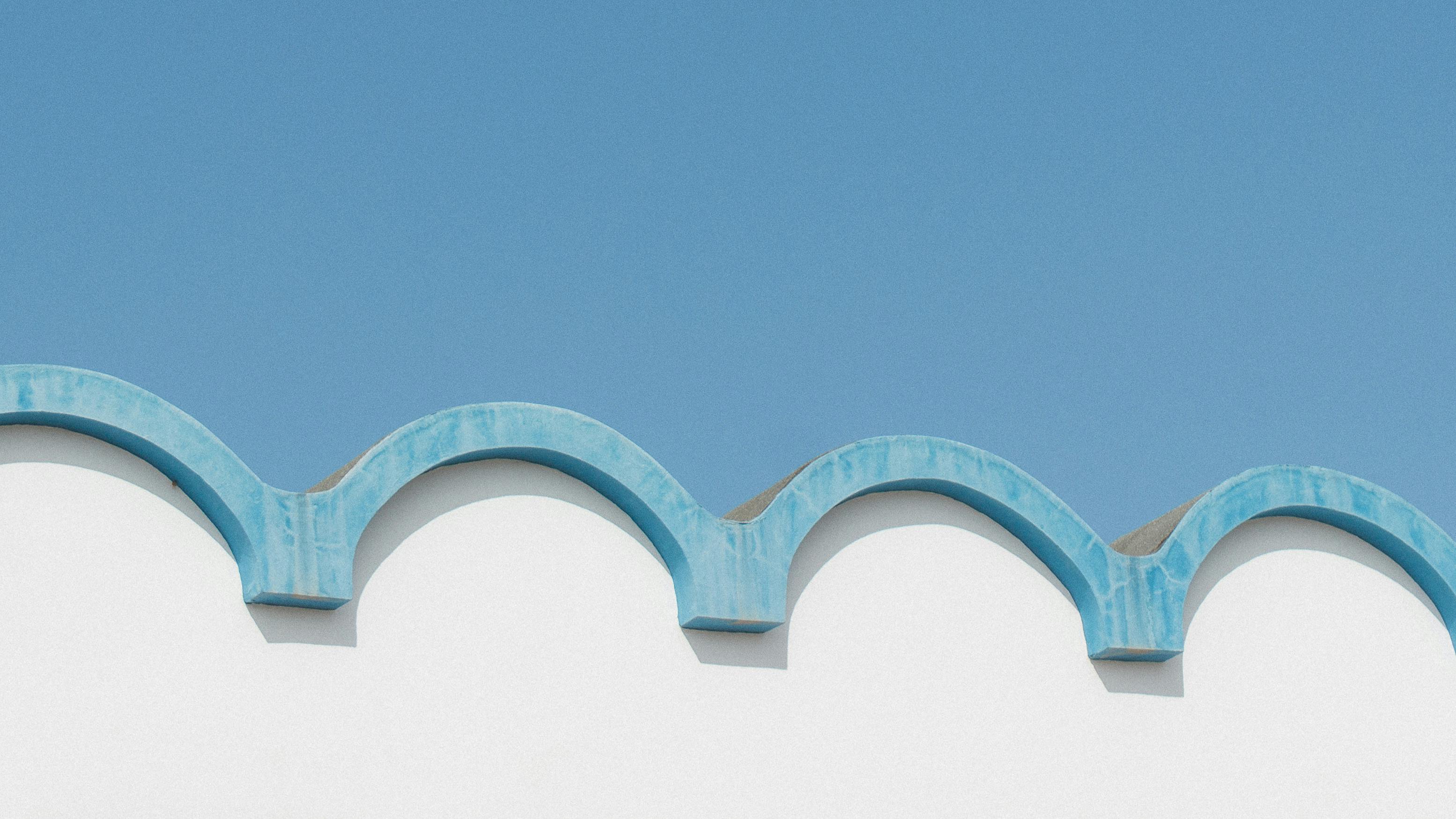 bezplatná Detailní záběr na modrobílou vlnitou střechu proti jasné modré obloze, minimalistický design. Základová fotografie