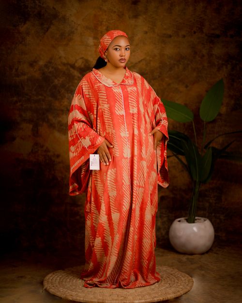 Free Woman in traditional red and orange attire posing indoors with plants. Stock Photo