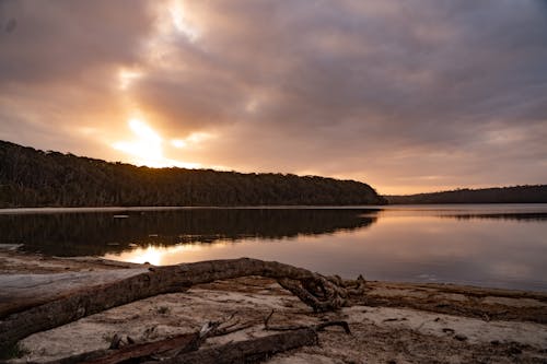 Ücretsiz Gün Batımında Sakin Suyu Olan Bir Gölün Görünümü Stok Fotoğraflar