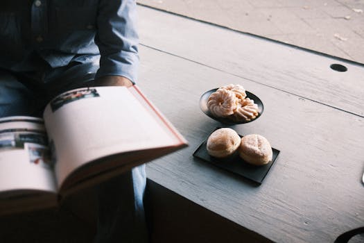 Calm cafe atmosphere with pastries and a person reading a book.