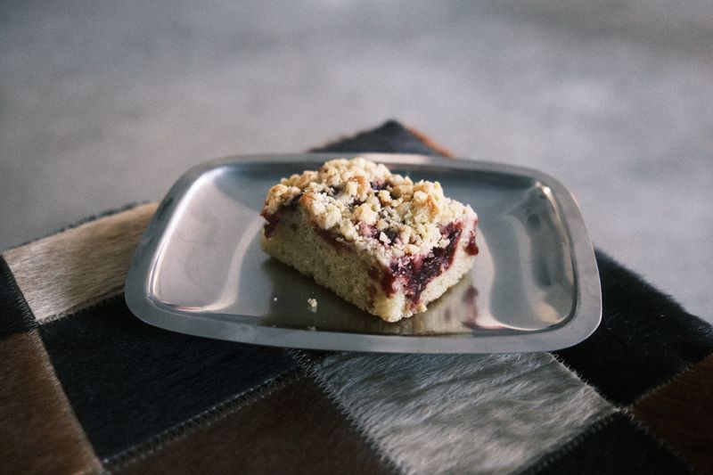 Appetizing berry crumble bar served on a sleek metal plate.