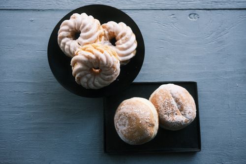 Free A flat lay of donuts and pastries on a rustic blue table creating a delightful scene. Stock Photo