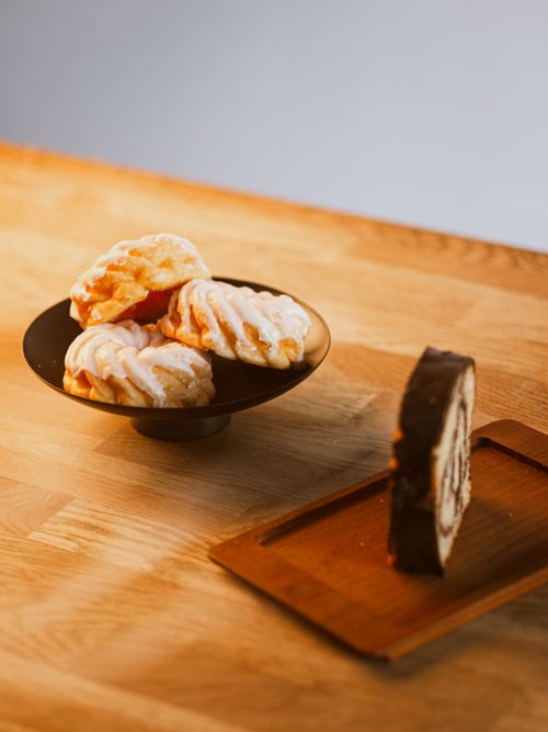 Free A variety of German pastries including a chocolate roulade and icing-covered danishes on a wooden table. Stock Photo