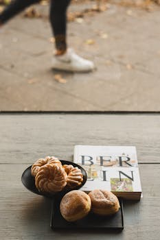 A selection of German pastries with a Berlin city guide on a wooden table, embodying a delightful urban breakfast scene.