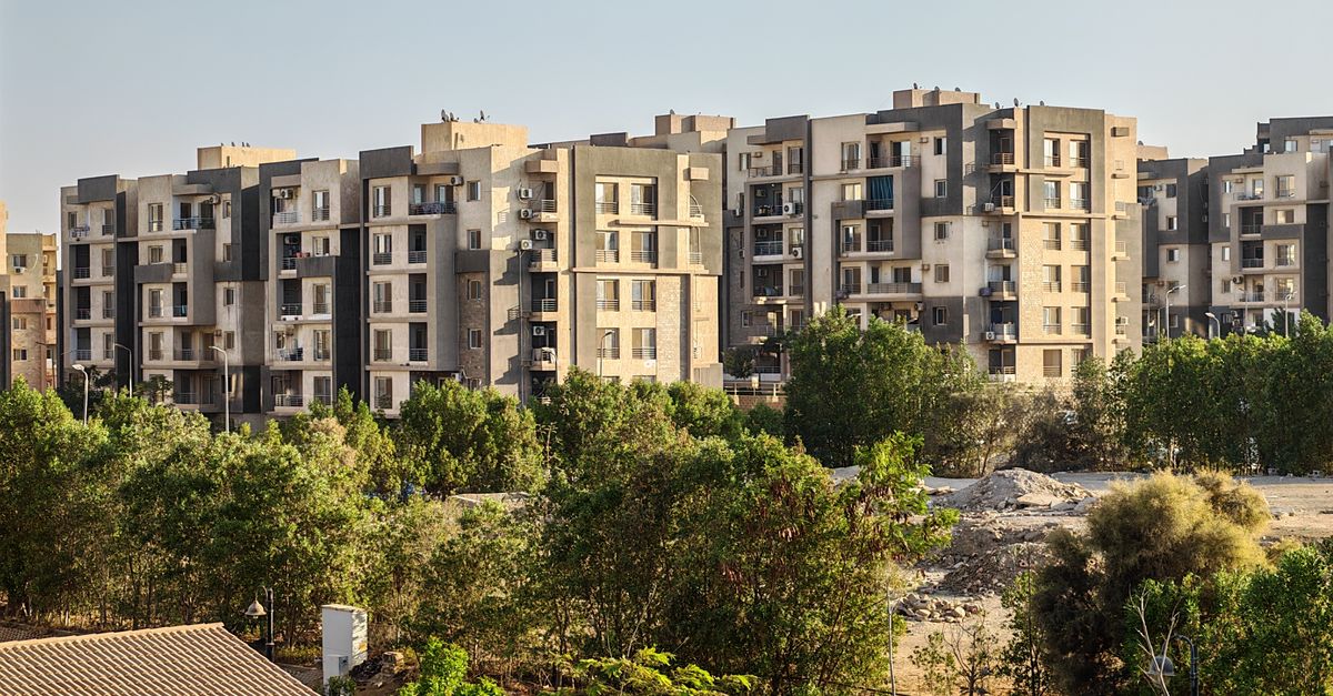 Contemporary apartment complex with lush greenery in urban setting.