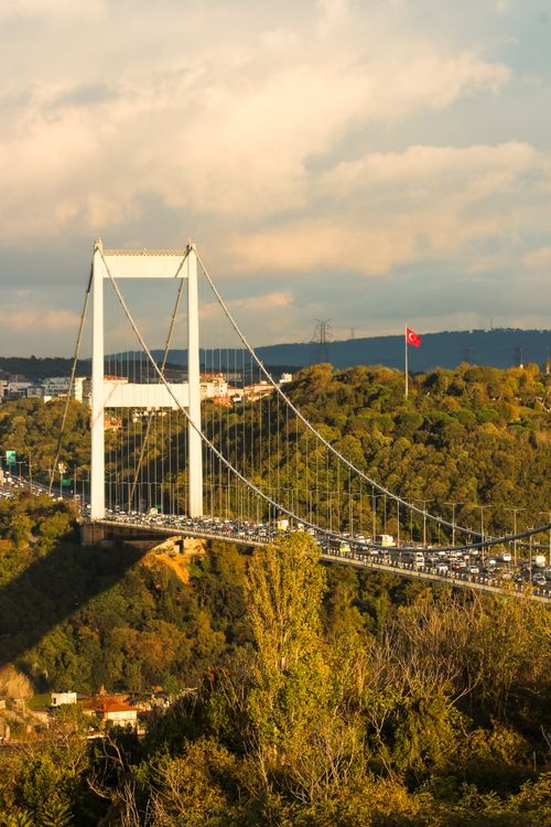 Free Scenic view of the Bosporus Bridge with traffic and Turkish flag, Istanbul during sunset. Stock Photo