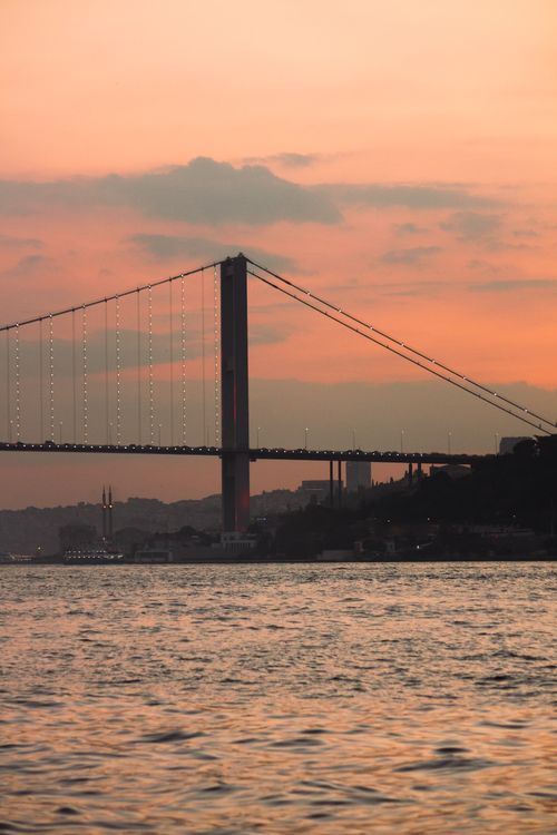 Free Scenic view of the Bosporus Bridge silhouetted against a golden sunset in Istanbul. Stock Photo