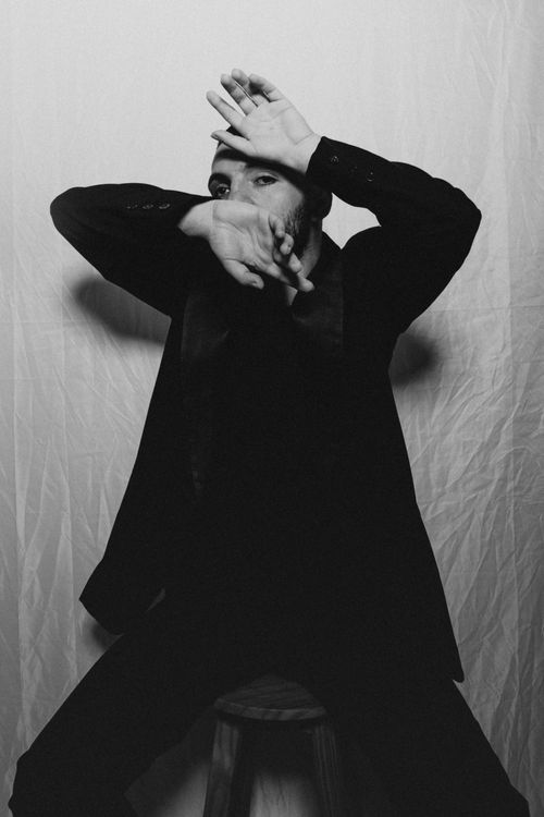Free Artistic black and white portrait of a man posing creatively in a suit. Stock Photo