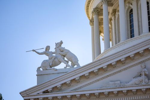 Free Close-up of a historical statue on the Sacramento State Capitol building with clear blue sky. Stock Photo