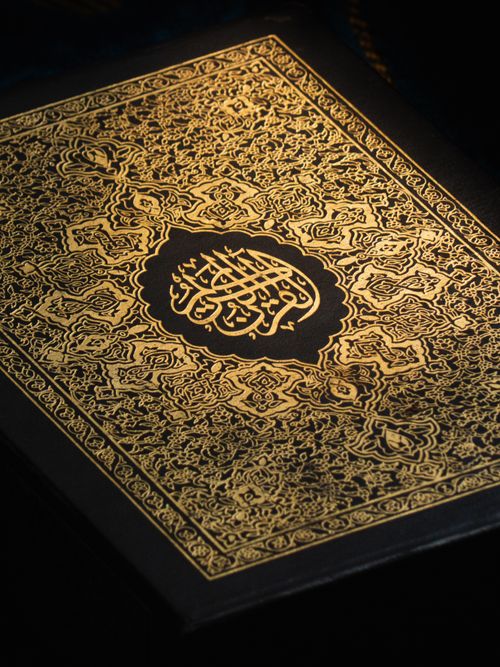 Free Elegant Quran cover in gold, showcasing intricate Arabic calligraphy and design. Stock Photo