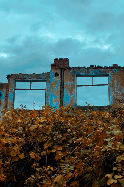 Free Ruined structure with vibrant autumn leaves and blue sky backdrop. Stock Photo