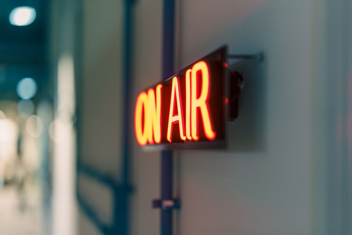 Red On Air neon sign in a broadcast studio representing live streaming