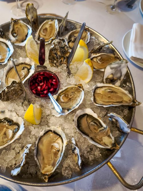Free Mouth-watering oyster platter on ice with lemon wedges and sauce, perfect for gourmet seafood lovers. Stock Photo