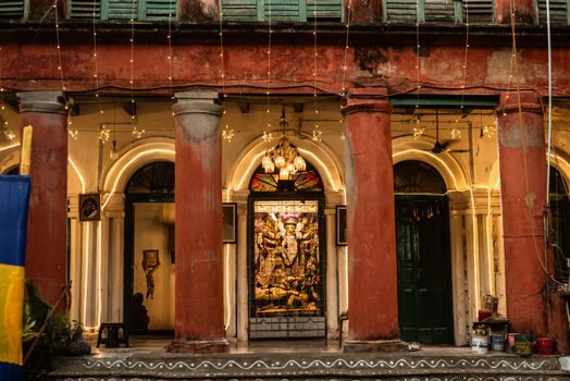 Colorful decorated heritage building with religious sculpture in evening lights.