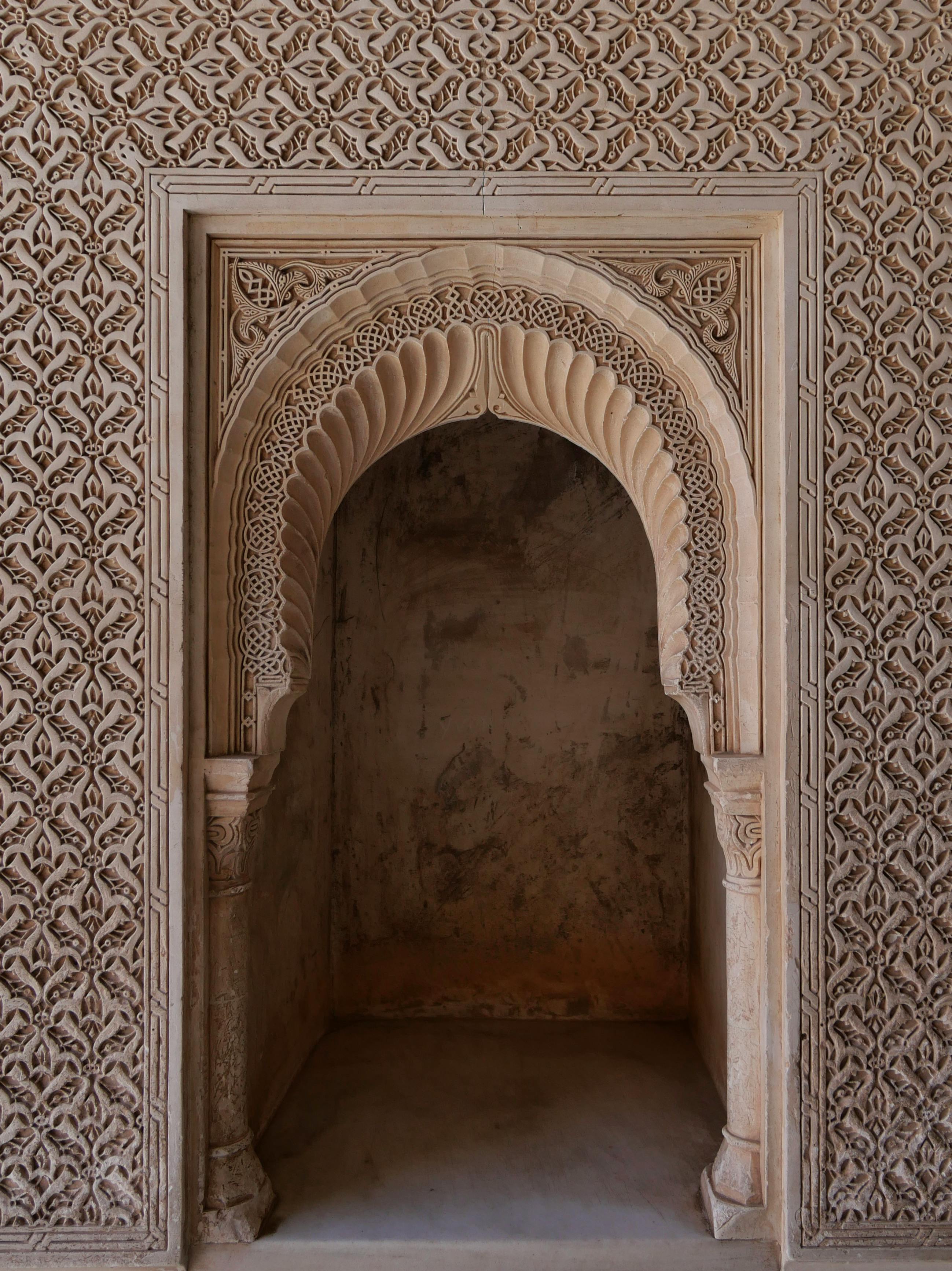 Detailed view of a Moorish arch with ornate carvings in the historic Alhambra Palace, Granada.