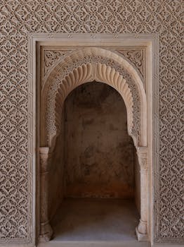 Detailed view of a Moorish arch with ornate carvings in the historic Alhambra Palace, Granada.