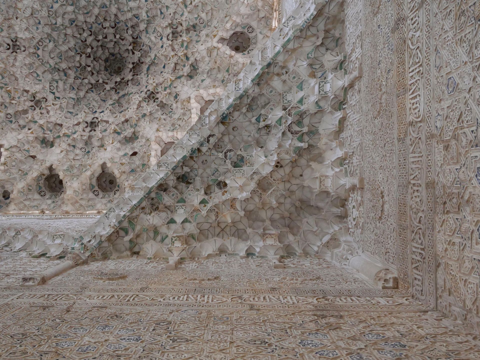 Detailed view of Moorish geometric plasterwork in the Alhambra, highlighting Islamic art and architecture.