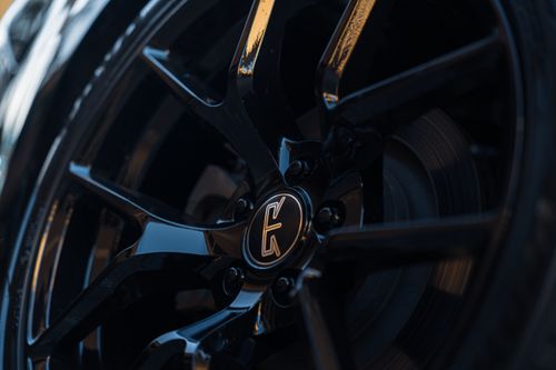 Free Detailed view of a glossy black alloy wheel rim highlighting its sleek and modern design. Stock Photo