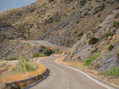 Scenic view of a winding road through arid mountains, ideal for adventure seekers.