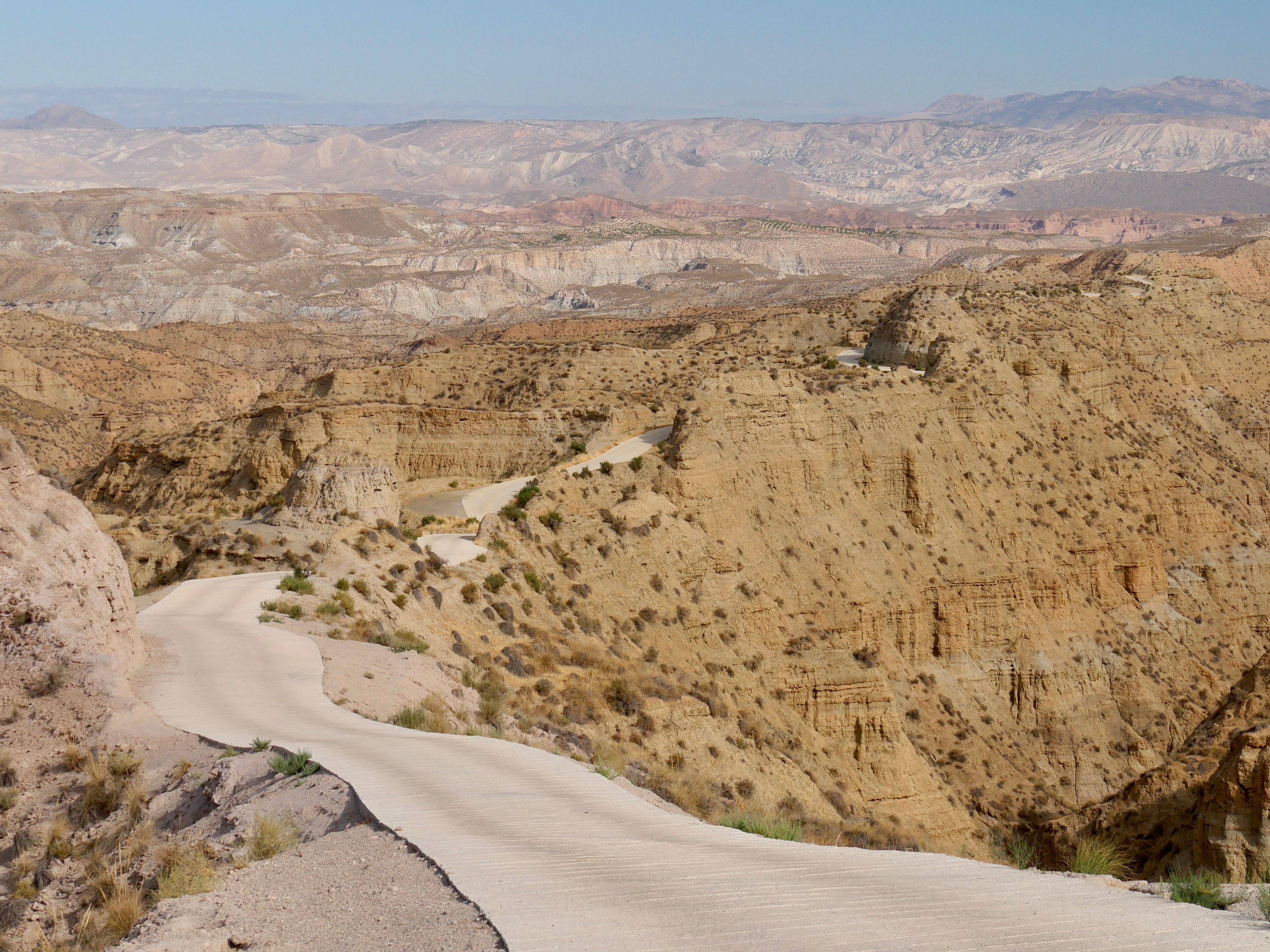 Scenic Desert Road Winding Through Rugged Terrain · Free Stock Photo