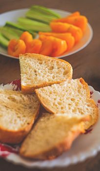 Close-up of sliced rustic bread with fresh vegetables in the background, creating a healthy, vibrant scene.