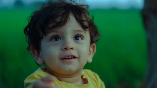 Free Charming portrait of a young child with lush green outdoor setting. Stock Photo