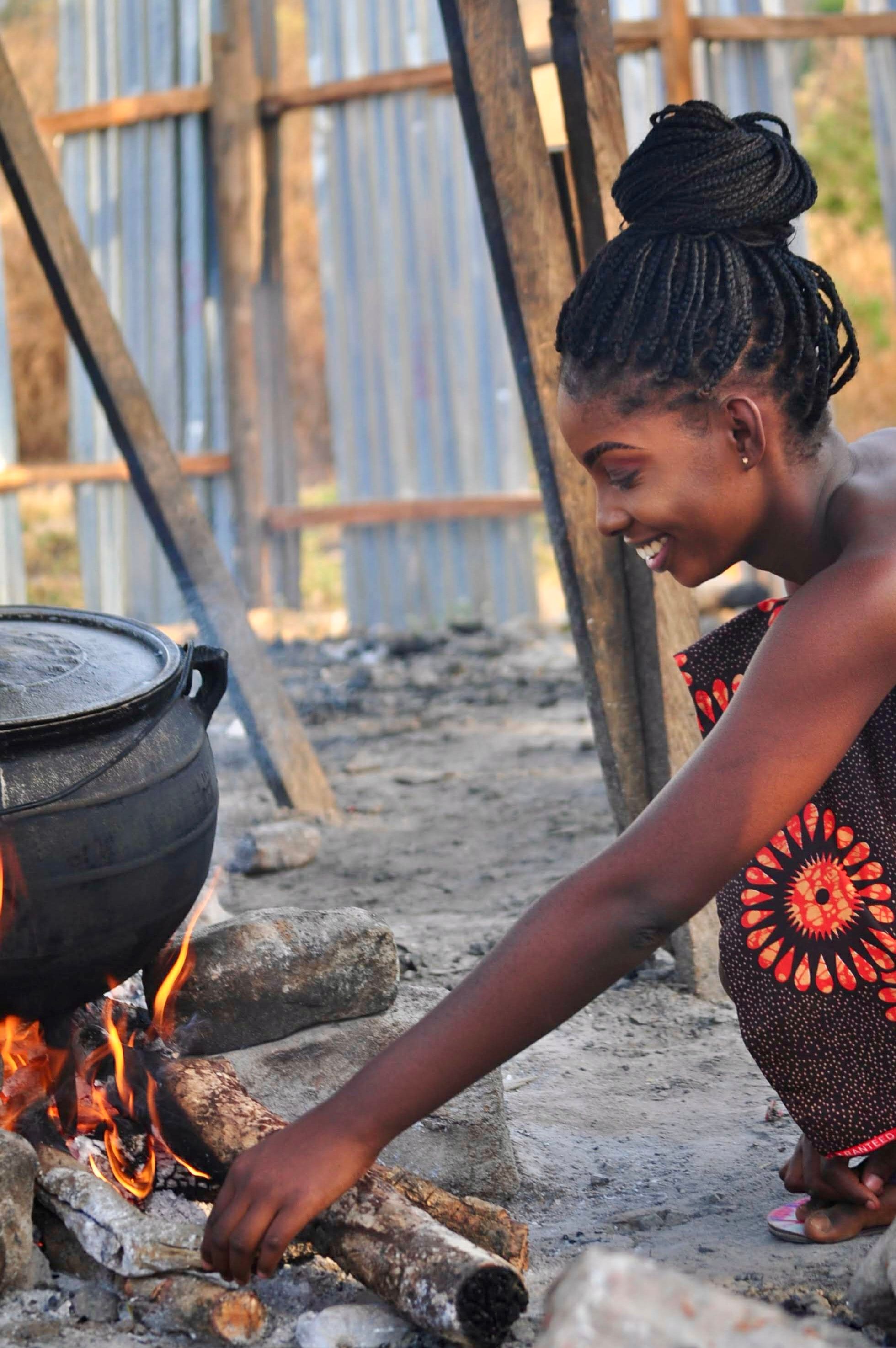 Nigerian Woman Cooking with Traditional Pot Outdoors · Free Stock Photo