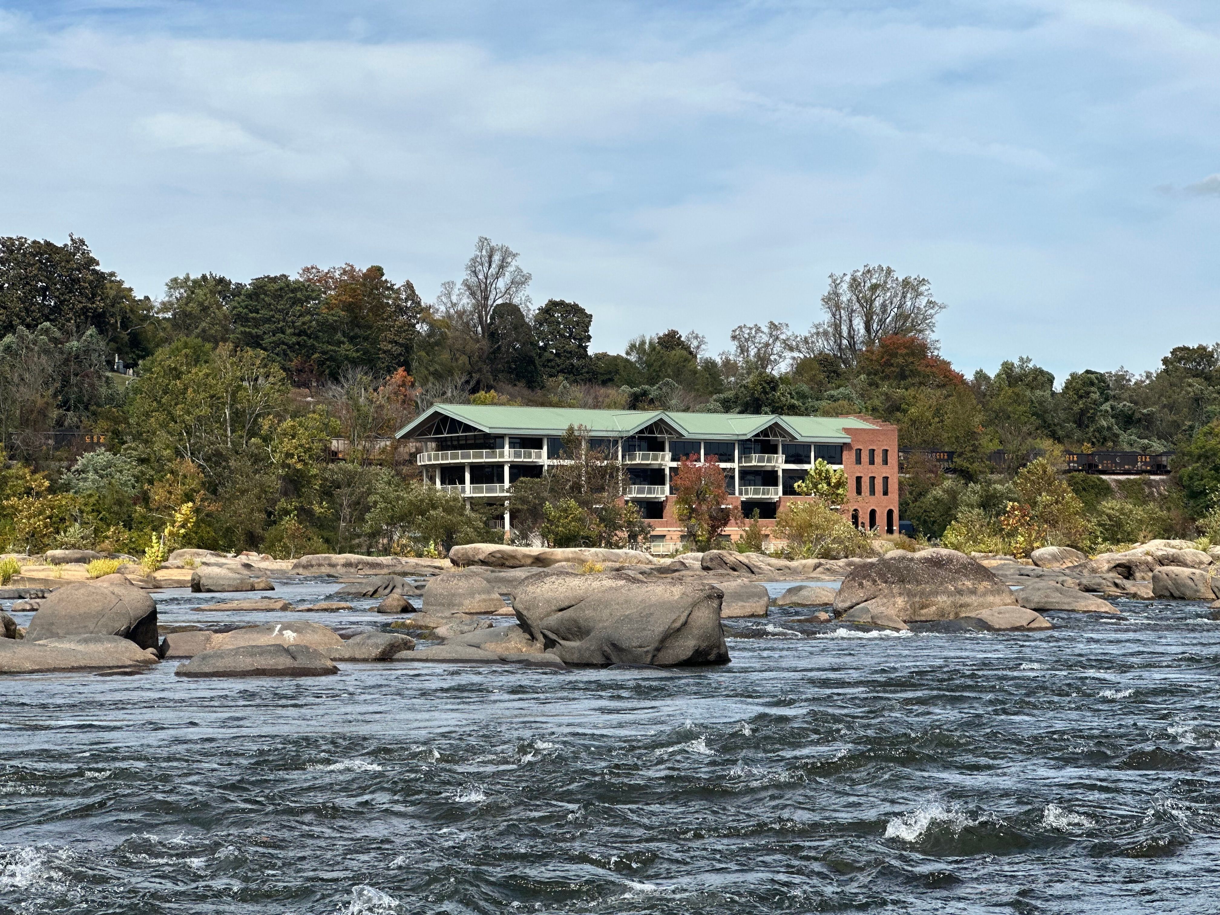 Scenic Riverside Building Amidst Autumn Foliage · Free Stock Photo