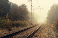 雾蒙蒙的秋天里，铁路轨道消失在五颜六色的树木中