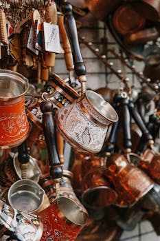 Vibrant Turkish coffee pots with intricate designs in a bustling market display, showcasing traditional craftsmanship.