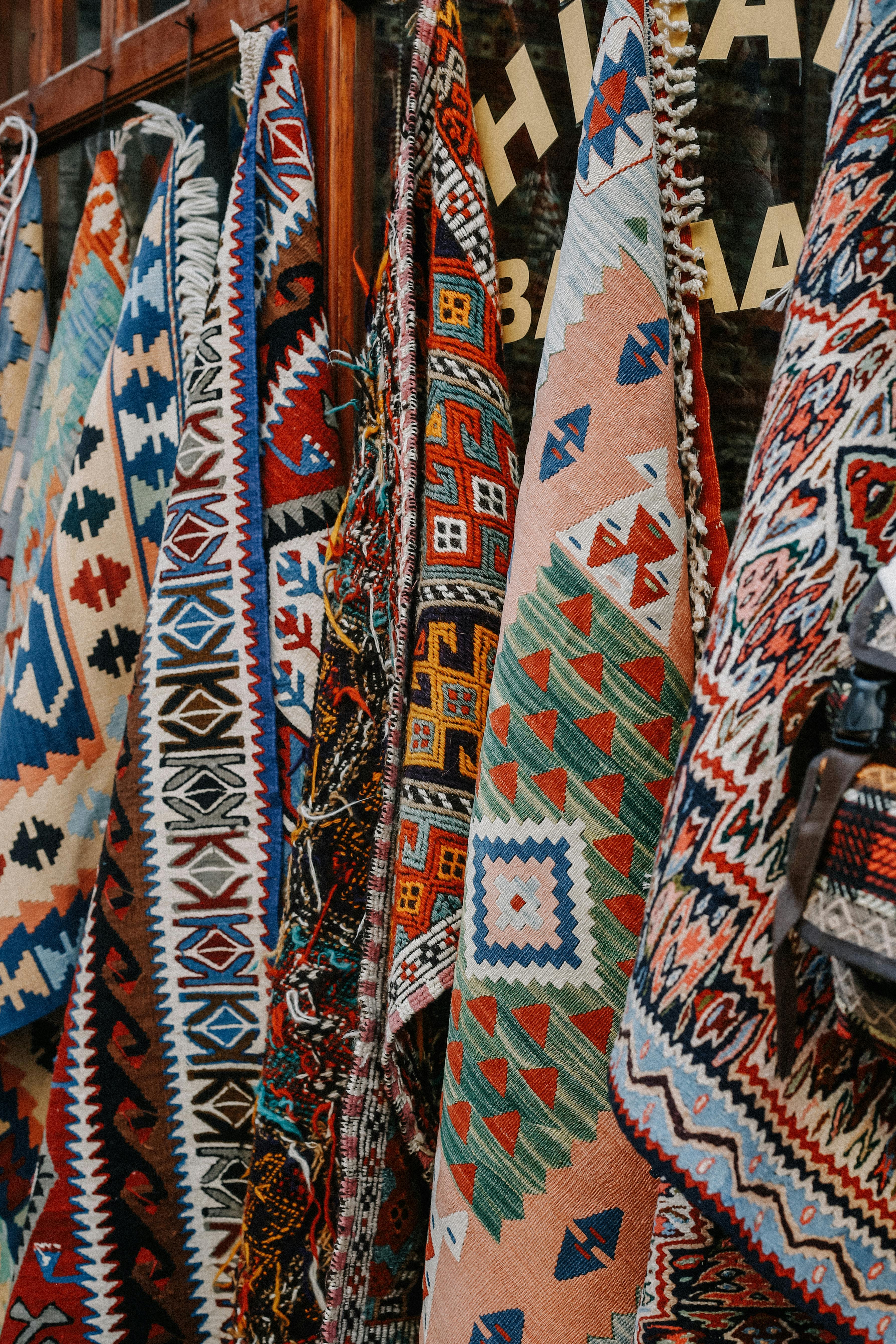 A vibrant display of traditional Turkish kilims featuring geometric patterns and rich colors.