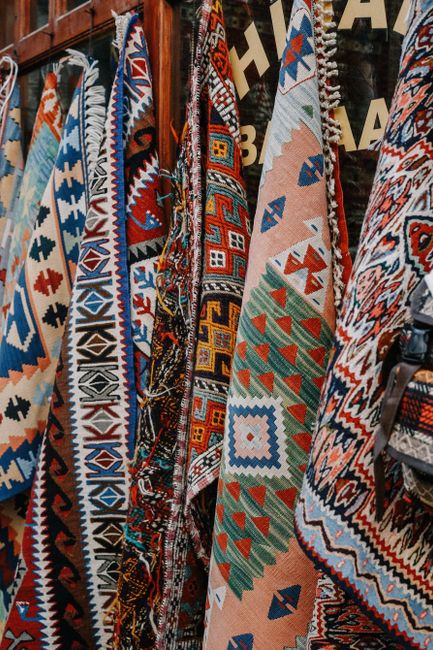 A vibrant display of traditional Turkish kilims featuring geometric patterns and rich colors.