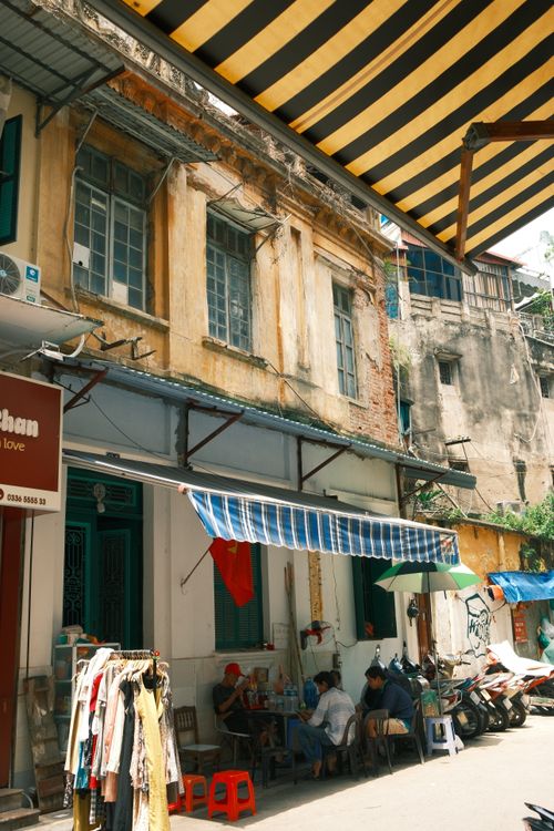 Free Charming Hong Kong street featuring a local market and outdoor café under shaded awnings. Stock Photo