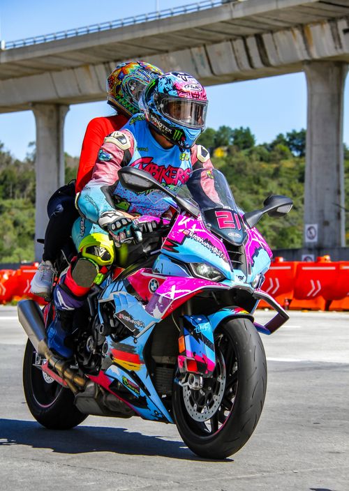Free Vibrant motorcyclists racing on a track with colorful gear and bike. Stock Photo