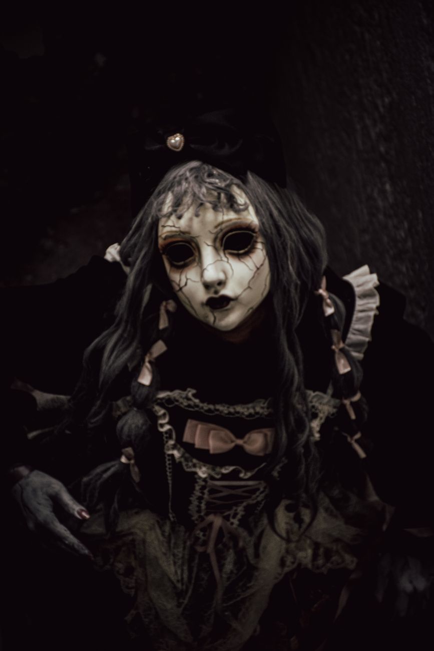Dark portrait of a creepy doll with cracked mask and gothic attire at night. dark, portrait, creepy