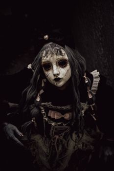 Dark portrait of a creepy doll with cracked mask and gothic attire at night. dark, portrait, creepy