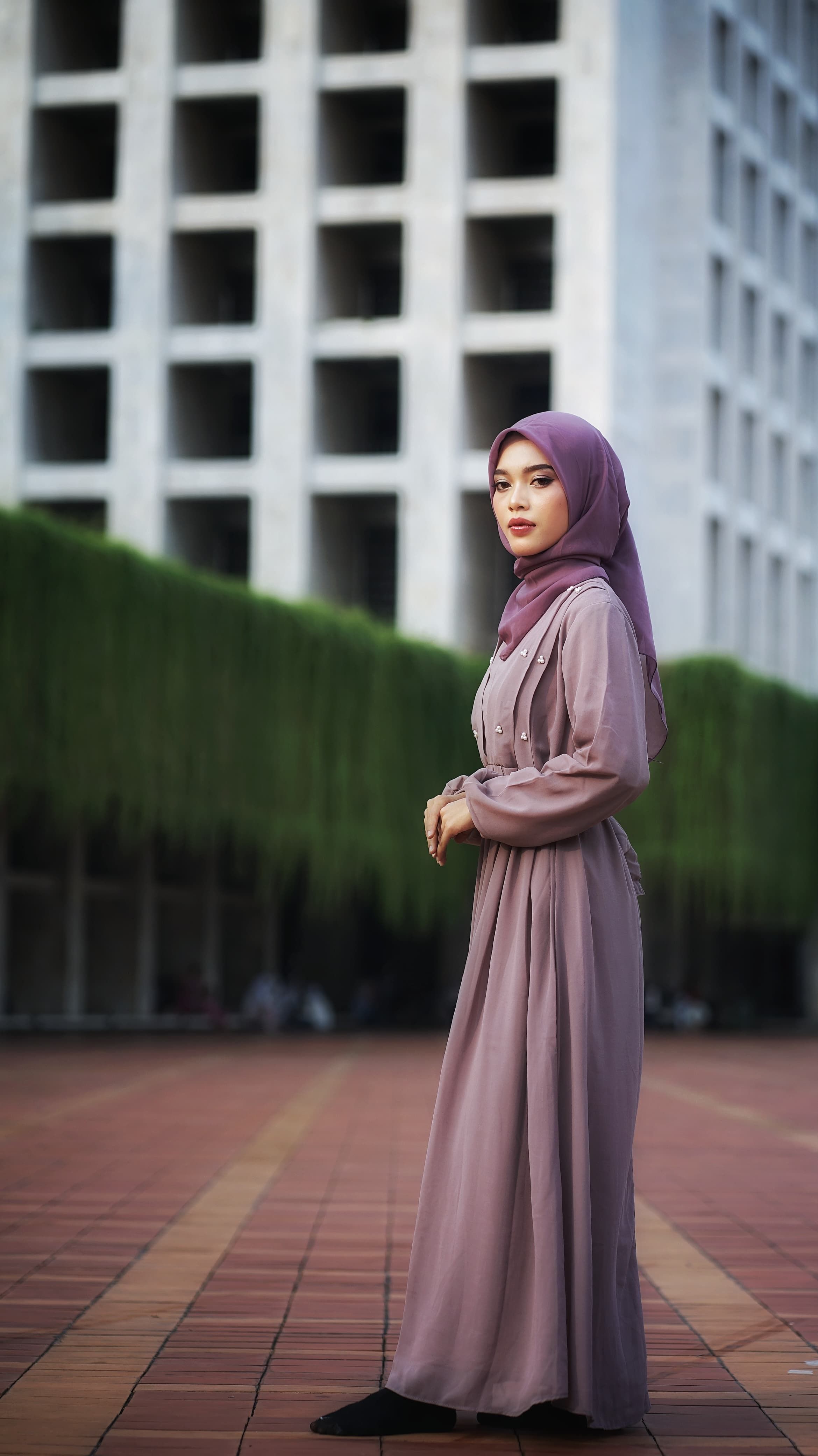 Elegant Woman in Purple Hijab Near Modern Architecture