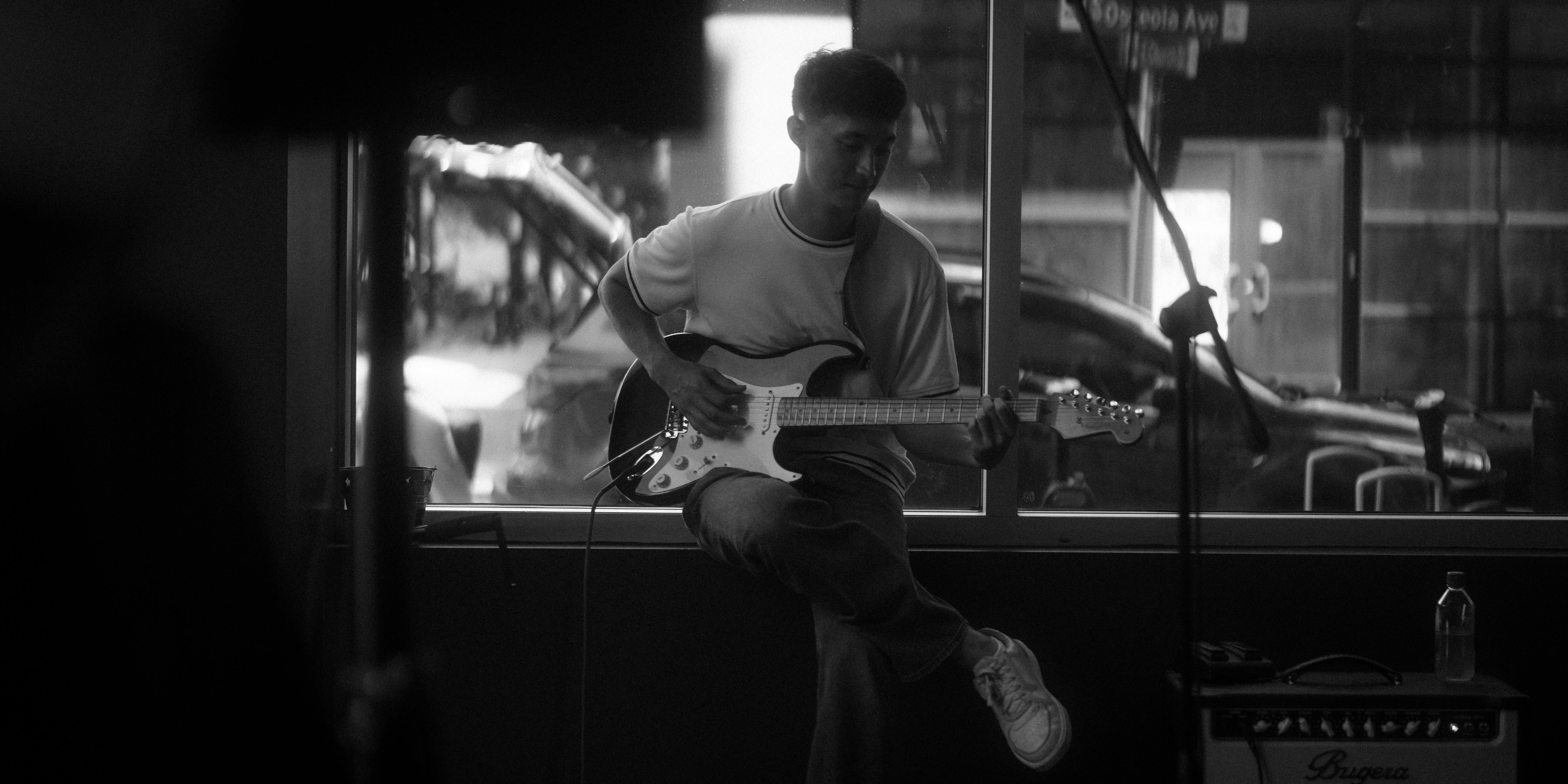 gratis Een gitarist die intiem binnen optreedt, met de nadruk op muzikale expressie. Stockfoto