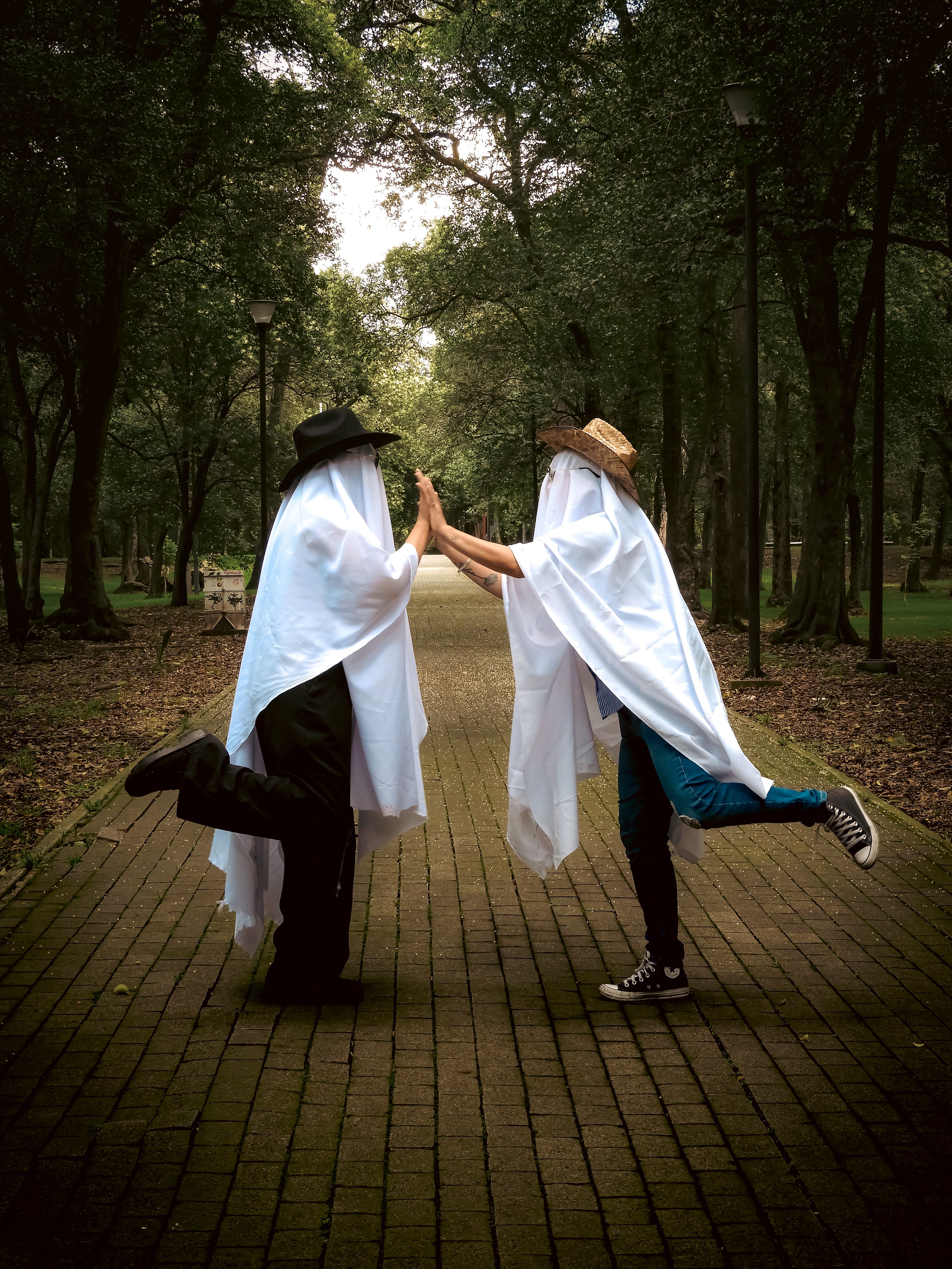 Playful Ghosts High-Fiving in Park · Free Stock Photo