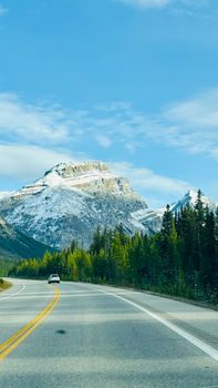 Beautiful drive through a mountain highway with stunning snow-capped peaks.