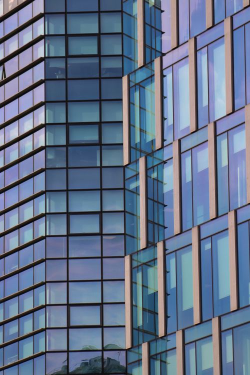 Free Close-up view of a modern glass facade showcasing reflections and architectural design in Milan. Stock Photo