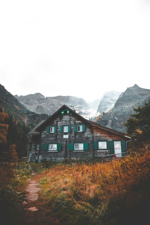 Free A charming wooden cabin nestled in Austria's foggy autumnal mountains, perfect for a serene escape. Stock Photo