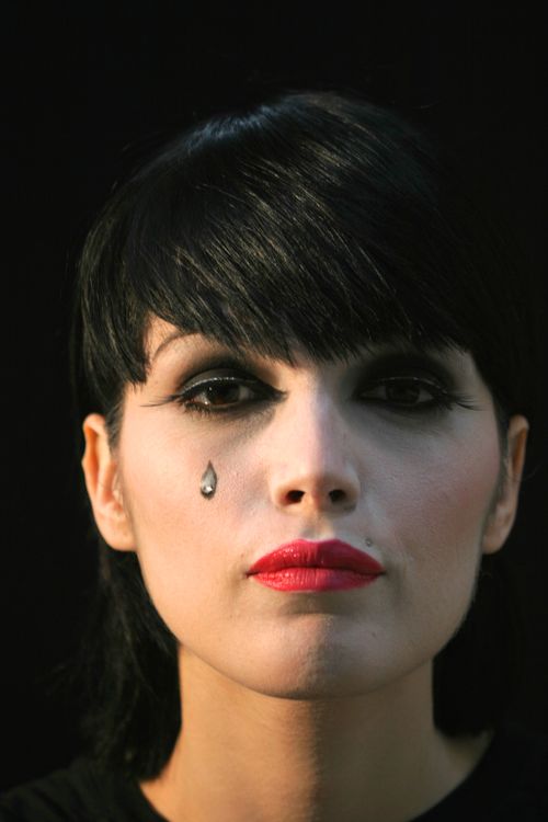 Free Close-up portrait of a woman with a single teardrop under her eye, evoking emotion. Stock Photo