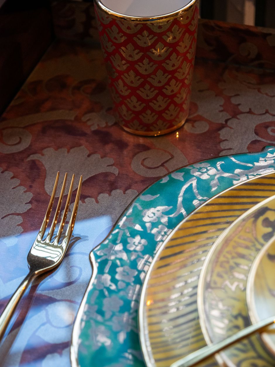 Luxurious dinnerware with gold accents and ornate designs in an elegant setting.