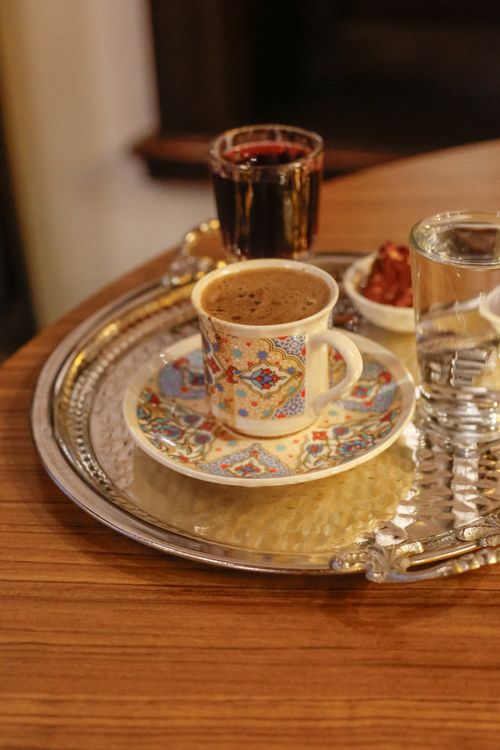 Free A close-up of Turkish coffee with intricate designs, served with water and Turkish delight. Stock Photo