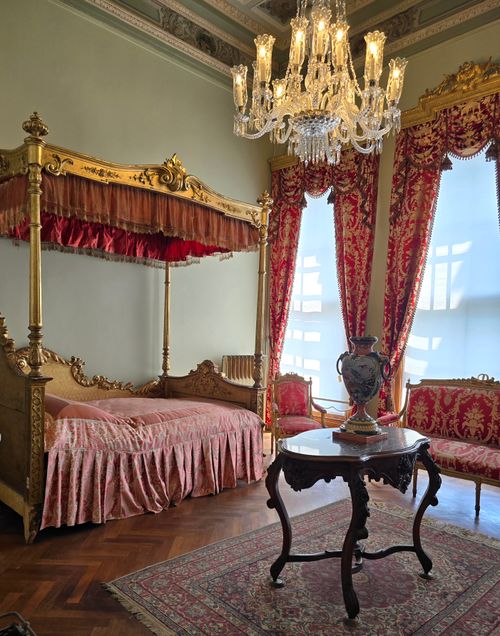 Free Ornate Ottoman-era bedroom featuring a lavish canopy bed and chandelier, capturing historic elegance. Stock Photo