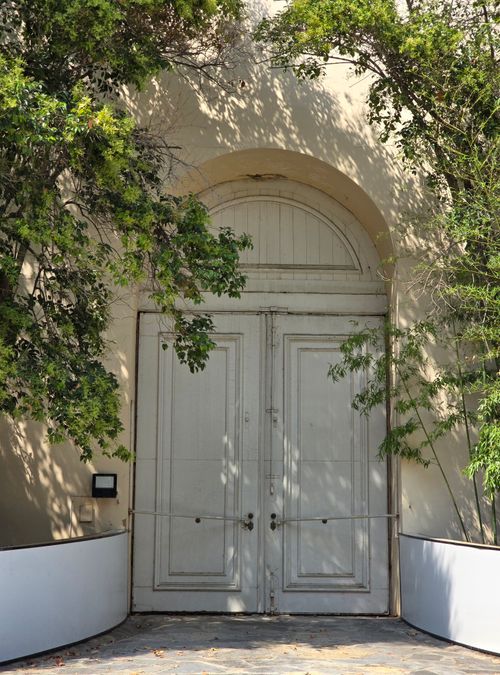 Free A sunlit historic arched doorway surrounded by lush greenery in Türkiye, offering a serene architectural view. Stock Photo