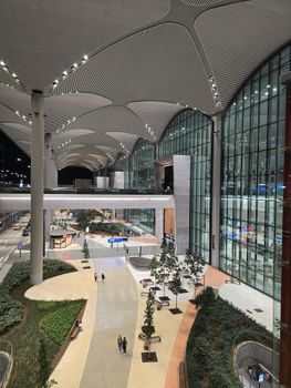 Night view of the stunning modern architectural design at Istanbul Airport, featuring expansive glass walls and elegant curves.