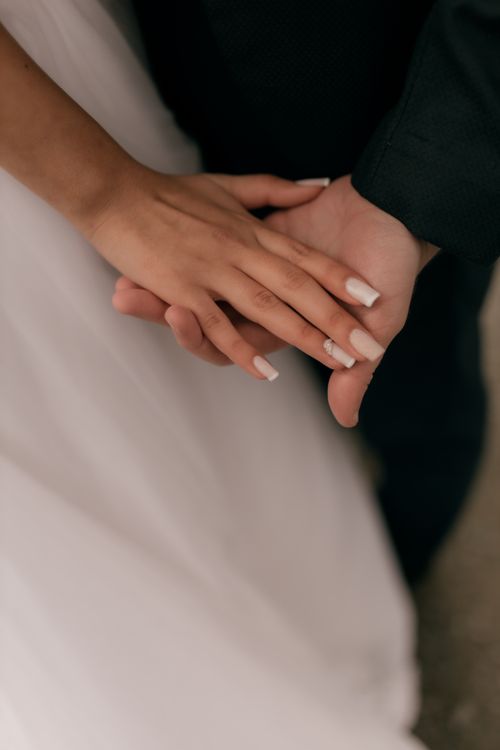 Free Close-up of a bride and groom's hands during a wedding ceremony, symbolizing love and commitment. Stock Photo