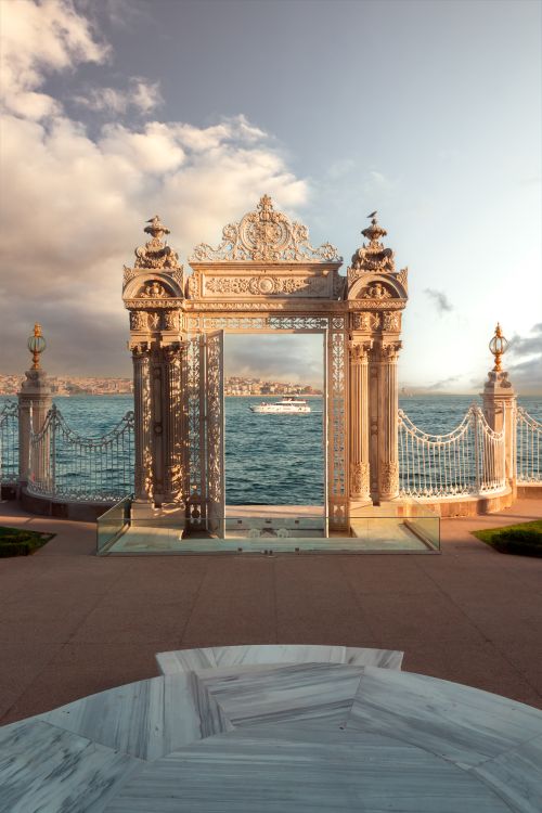 Free Ornate gate at Dolmabahçe Palace opening to Istanbul's scenic Bosphorus Strait. Stock Photo